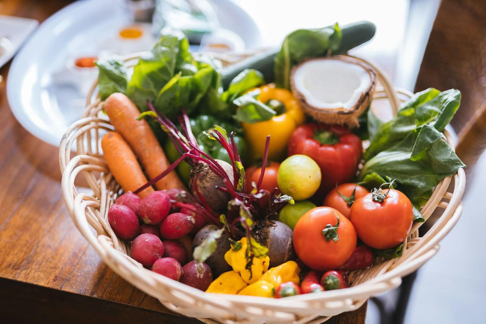 A basket of freshly picked vegetables — tomatoes, carrots, beetroot and capsicum